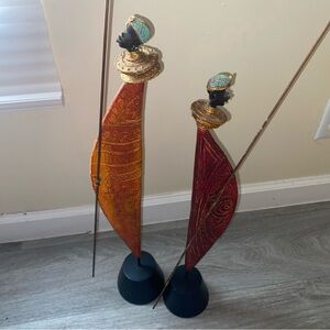 2 African figures made of metal and wood orange and red.